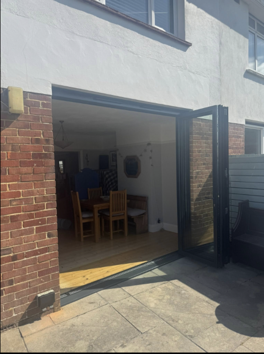 Grey aluminium bifold doors open onto a patio